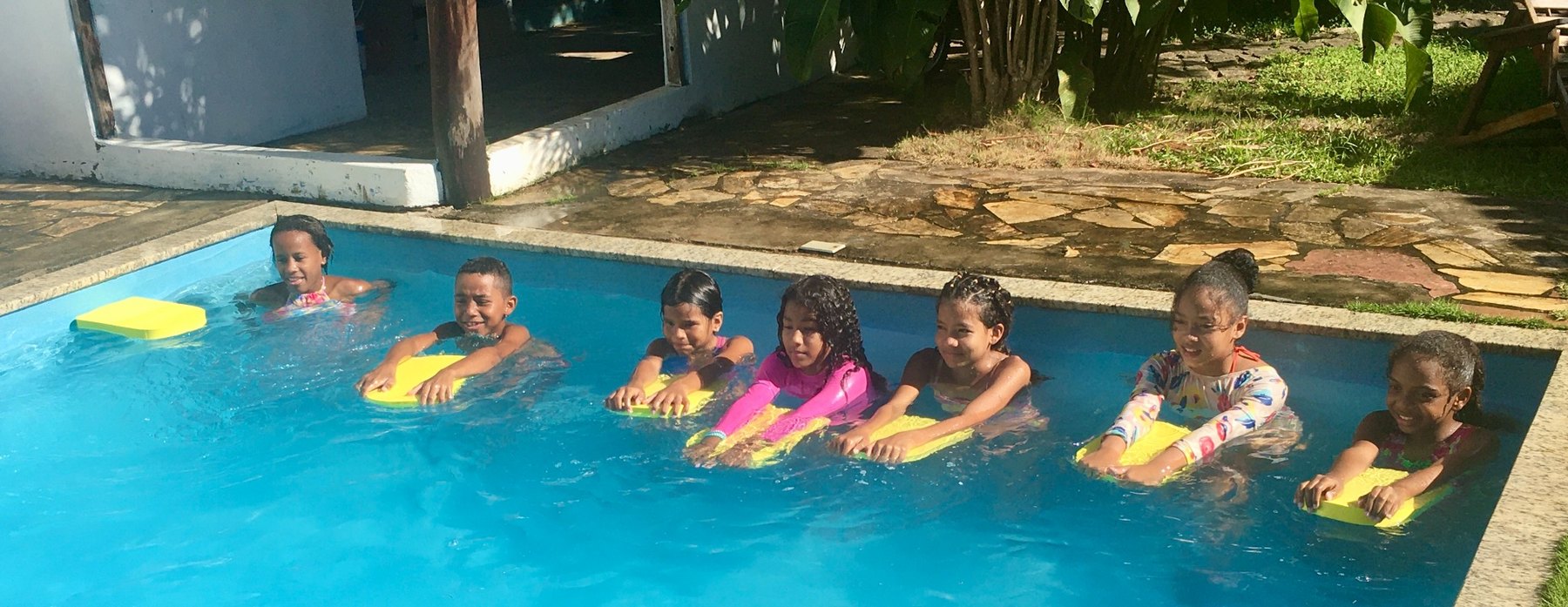 Children learning swimming skills using floats in a pool