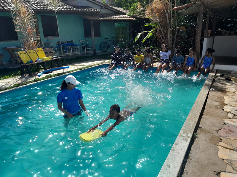 A child learning to swim with a kickboard during a lesson
