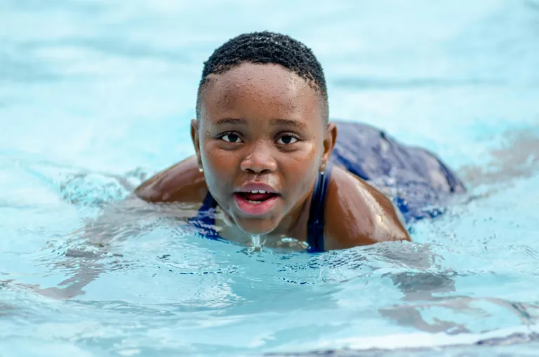 Children learning swimming and water-safety skills in open water